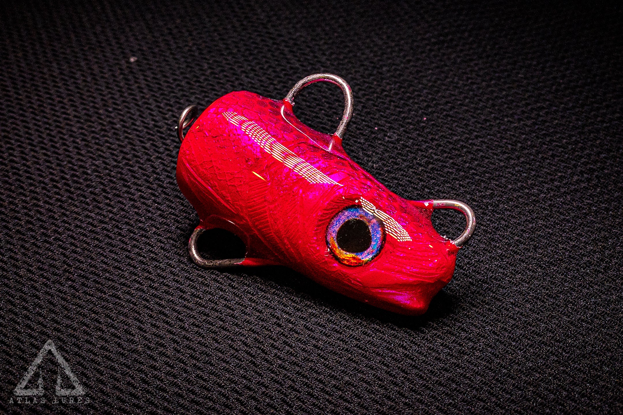 Red metallic lure on a textured black background