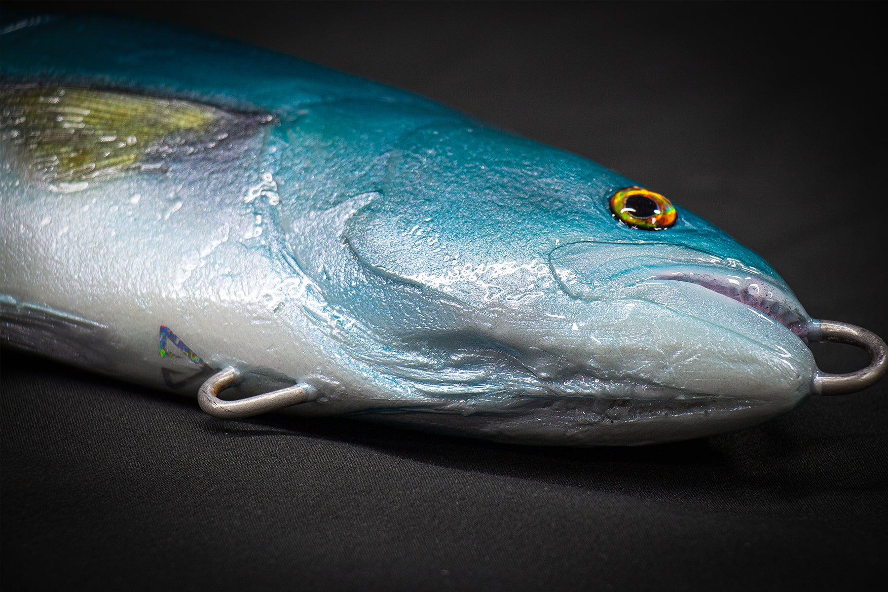 Blue fishing lure with a detailed face on a black background