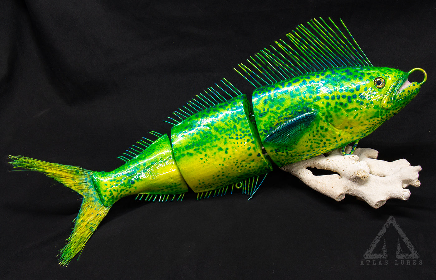 Green and yellow fish-shaped lure on a black background