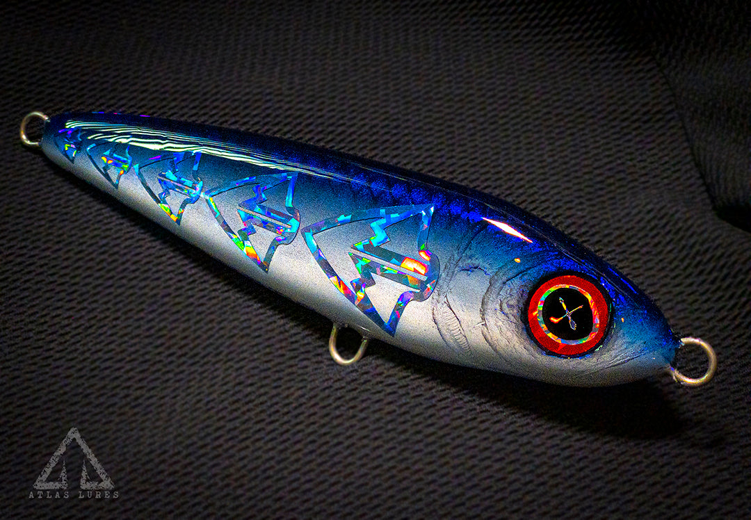 Fishing lure with blue and silver pattern on a dark background. March and Mill co. and Atlas Lures collab