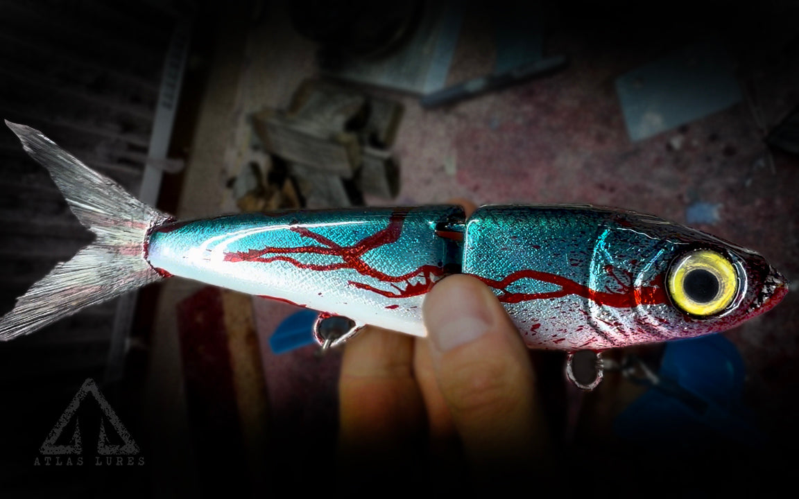 Close-up of a hand holding a detailed fish-shaped object with a dark background