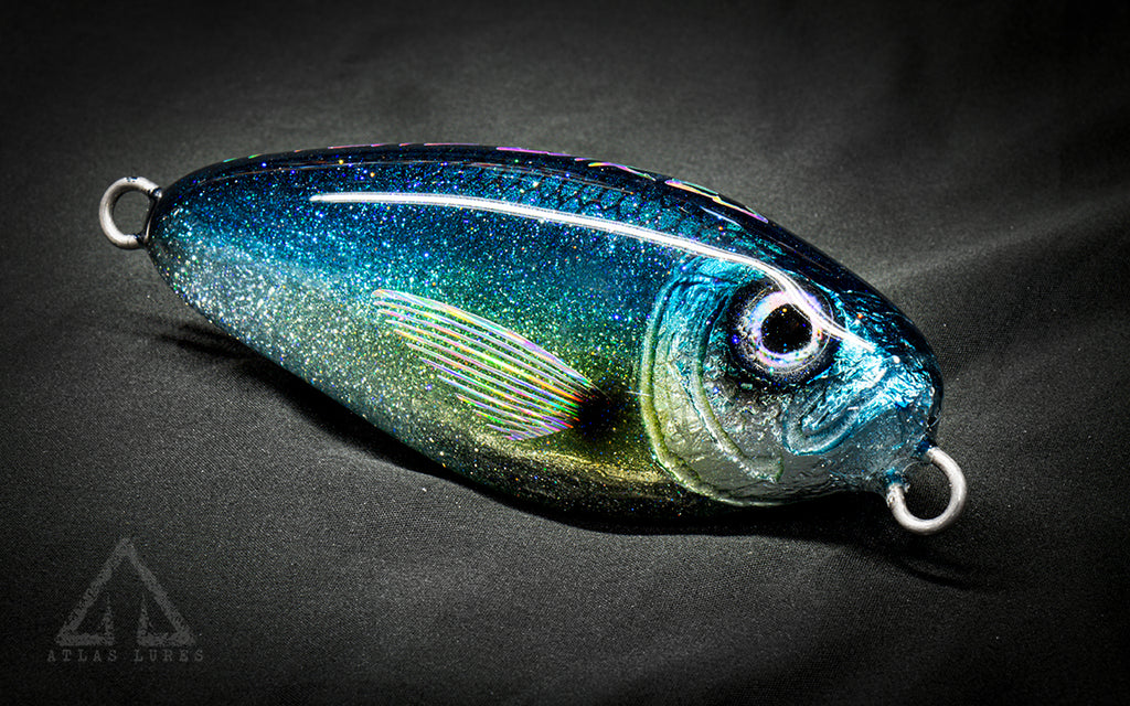 Blue and green glittery fishing lure on a dark background