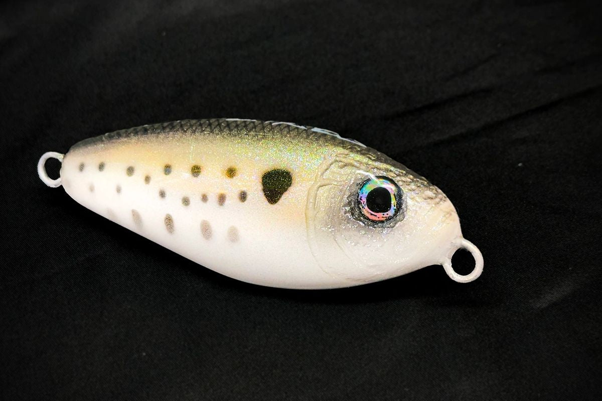Fishing lure with a black dot on a dark background made in USA