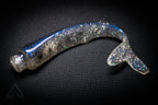 Shiny metallic object on a textured black background