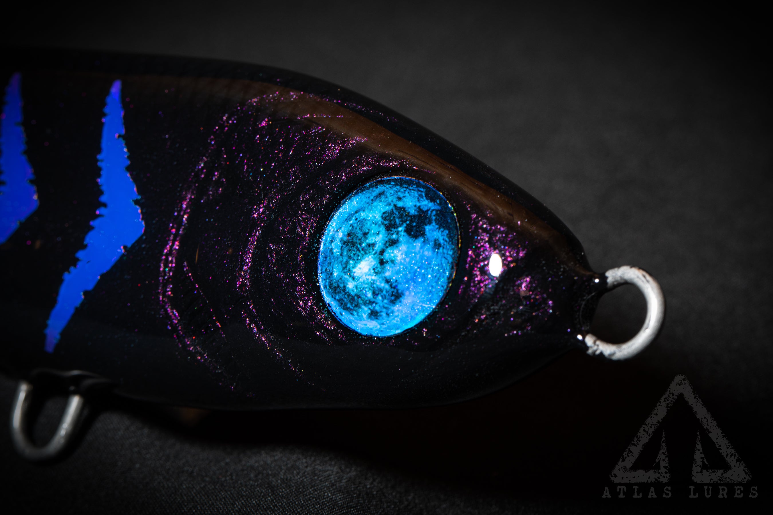Hand Poured resin Fishing lure with glowing blue eye on a dark background