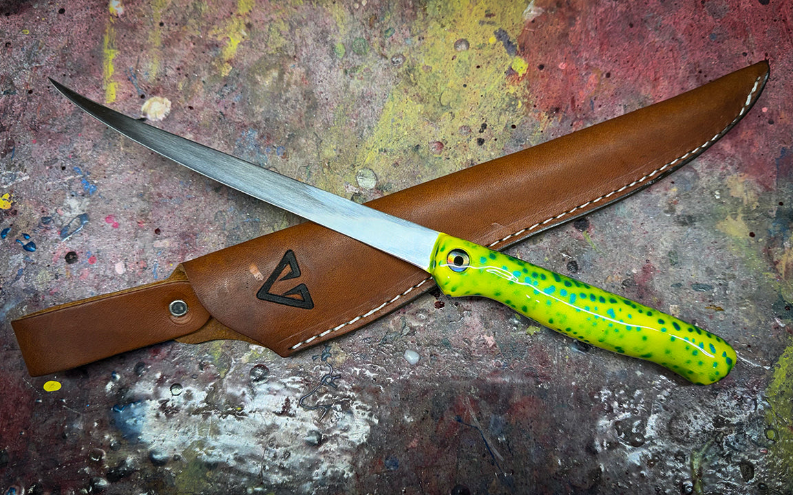 Knife with a yellow handle and leather sheath on a textured surface