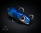 Blue metallic fishing lure with a rainbow eye on a black background
