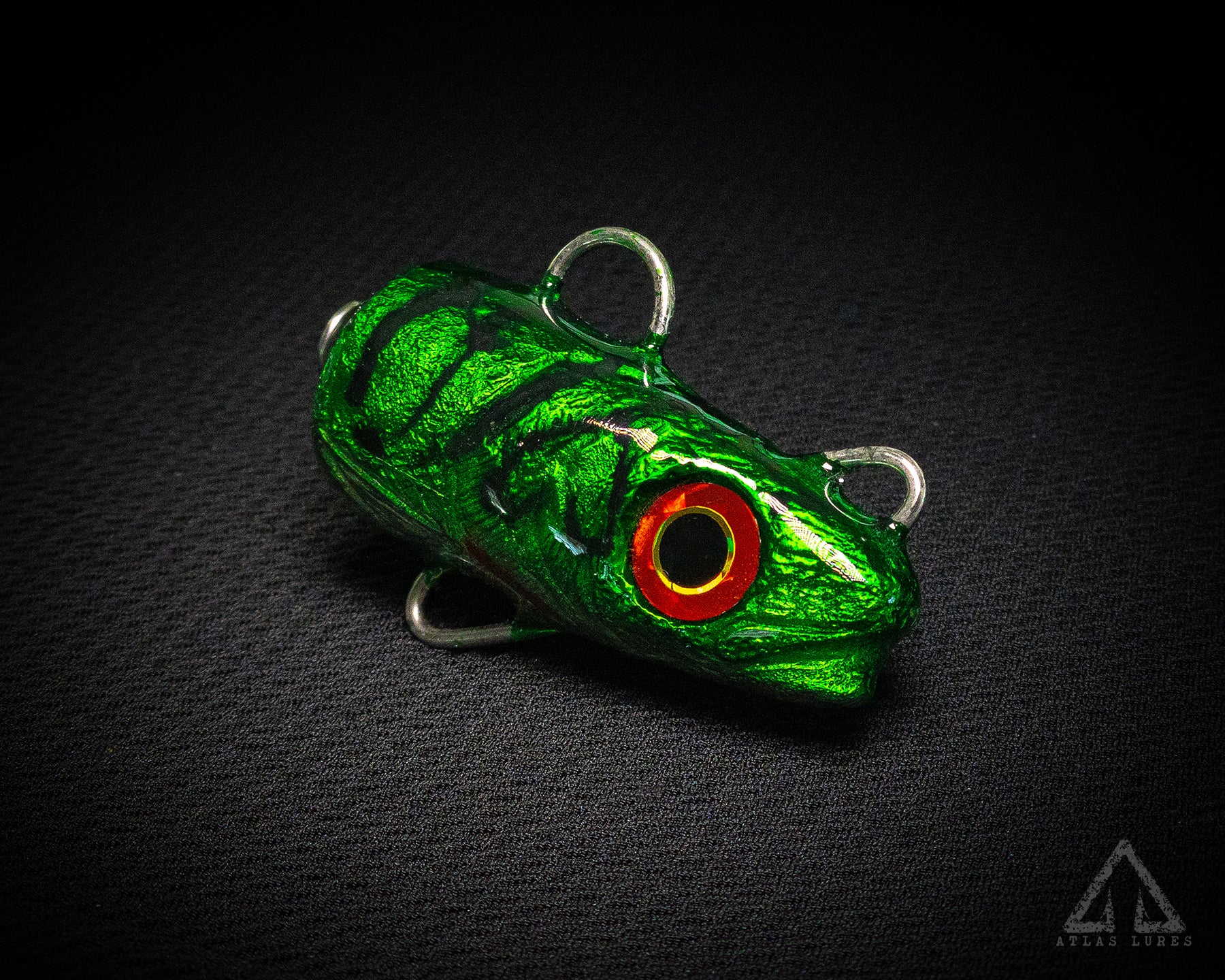 Green and red fishing lure on a black background