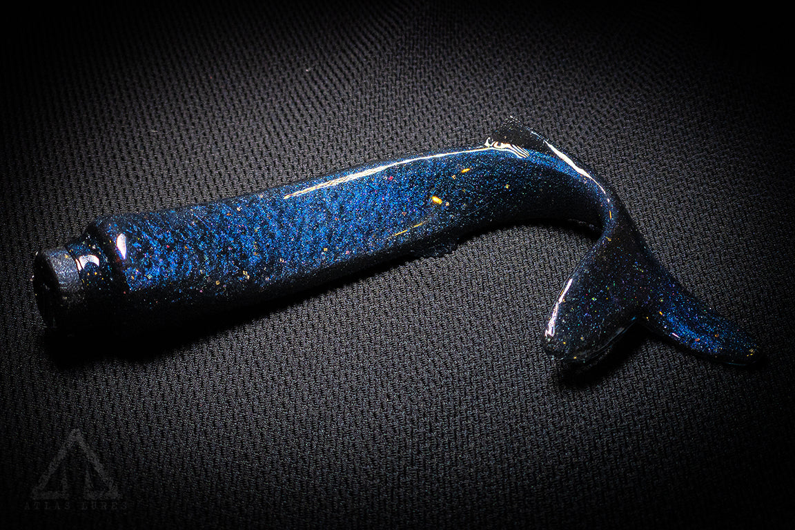 Blue fishing lure with a speckled pattern on a dark textured background
