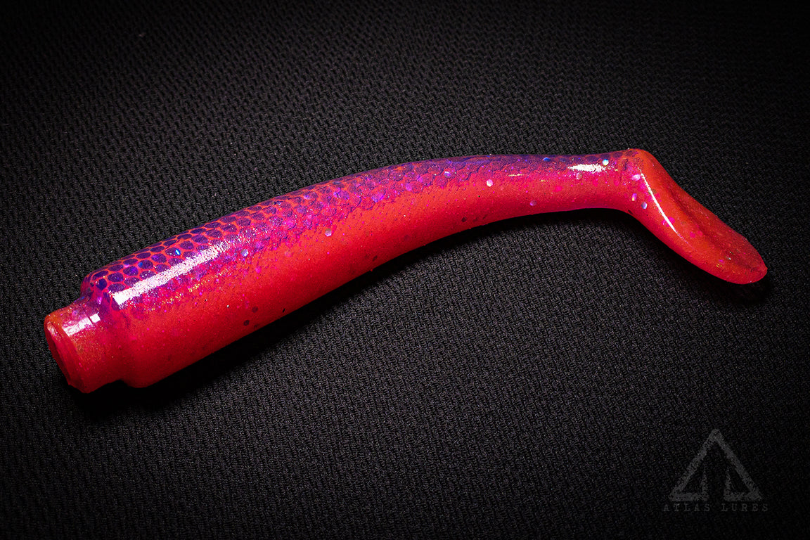 Red and purple fishing lure on a black background