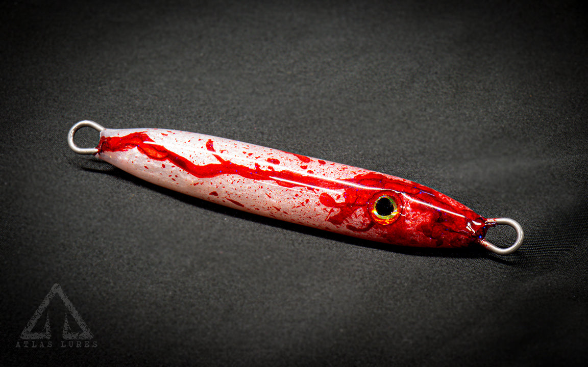 Hand poured resin blood and white fishing lure on a dark background