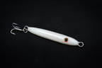White fishing lure with a hook on a black background. Handmade in USA