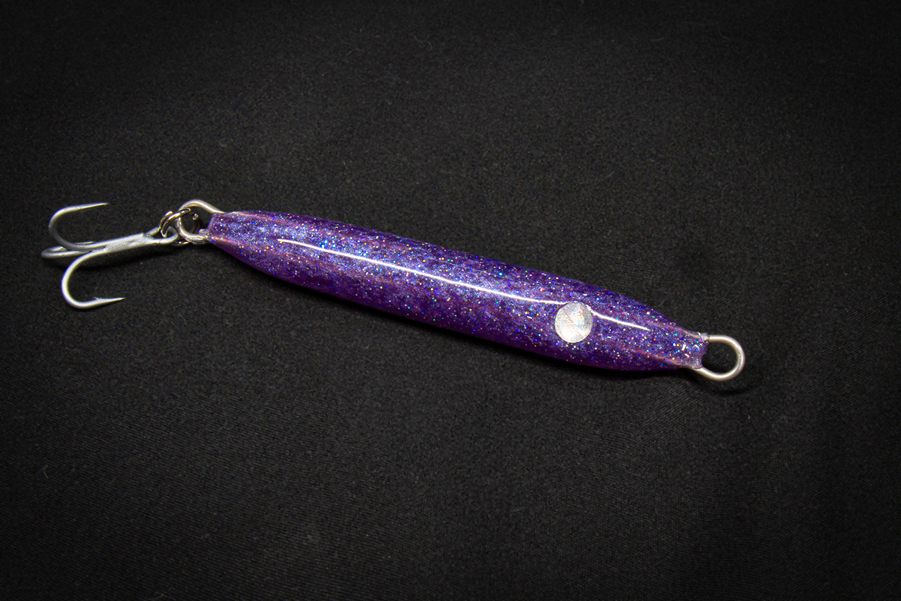 Purple glittery fishing lure with a black background