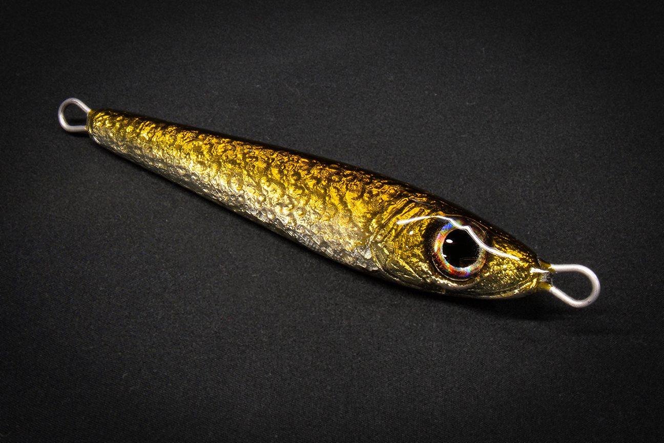 Metallic gold fishing lure on a black background. Made in USA