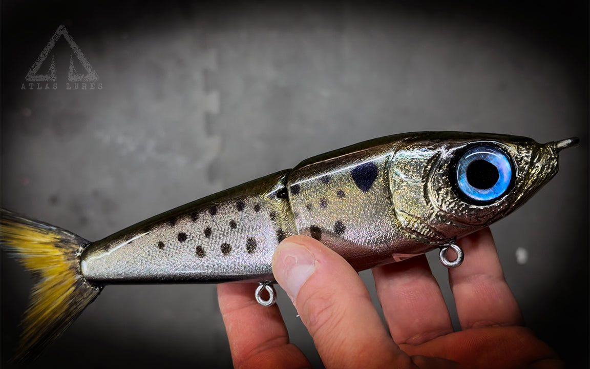 Fishing lure held in hand with a dark background