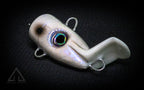 White fishing lure with a dark eye on a black background