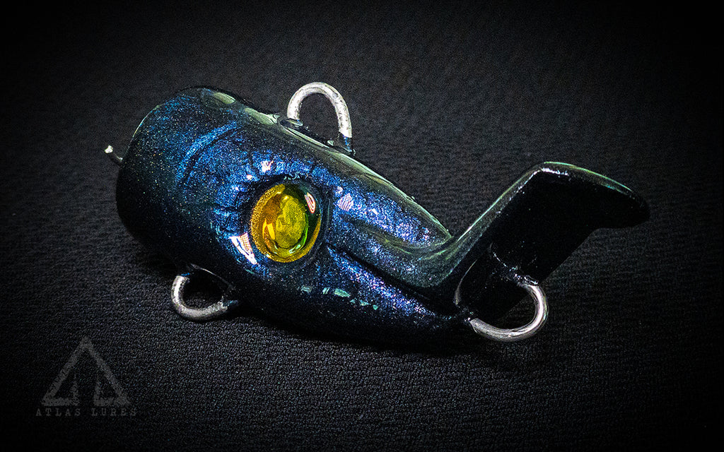 Fishing lure with blue and green color scheme on a dark background