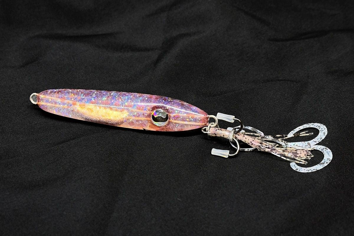 Hand poured resin Fishing lure with a glittery finish on a black background
